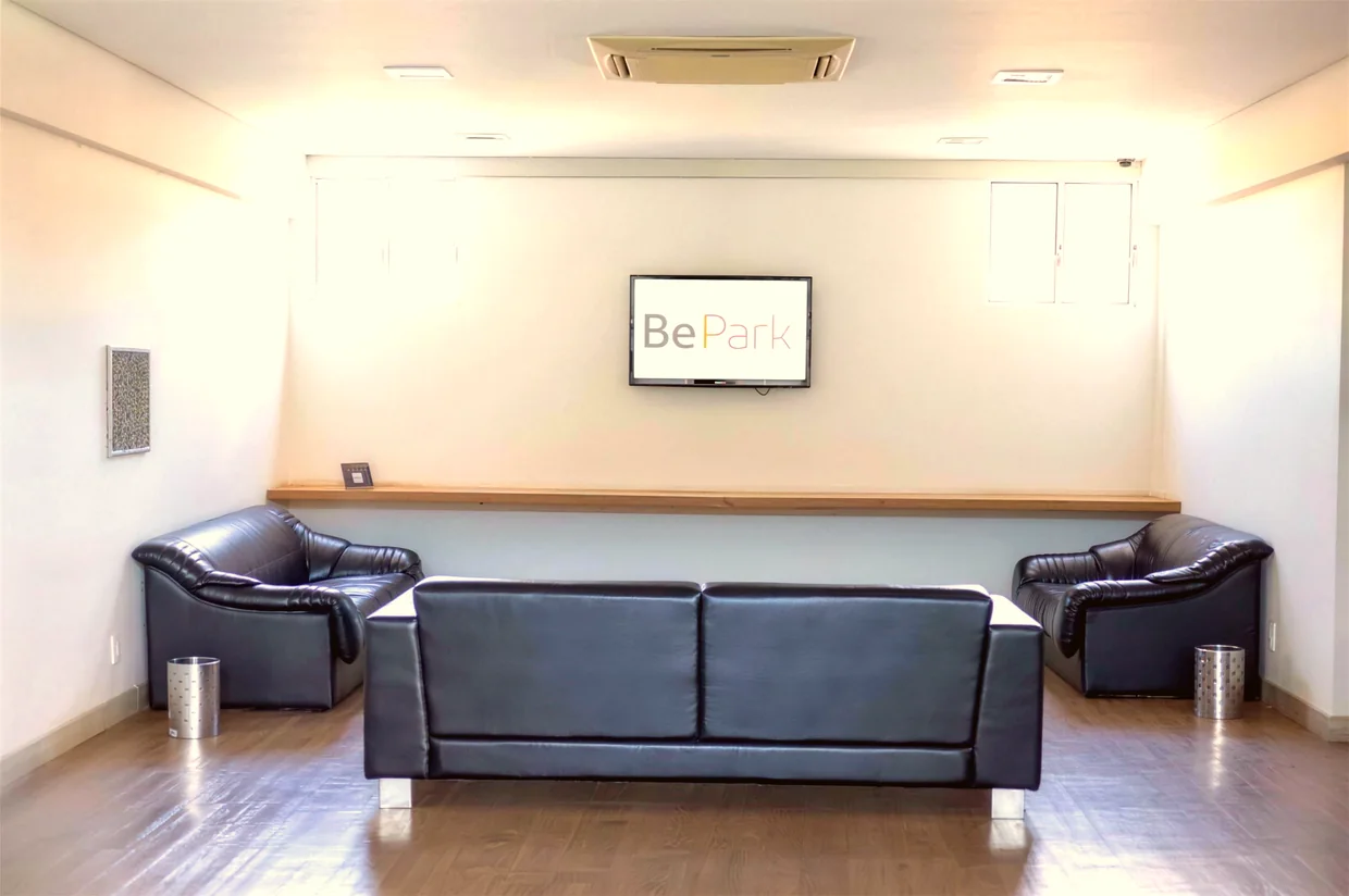 Sala de espera do BePark, com sofás, café e luz natural